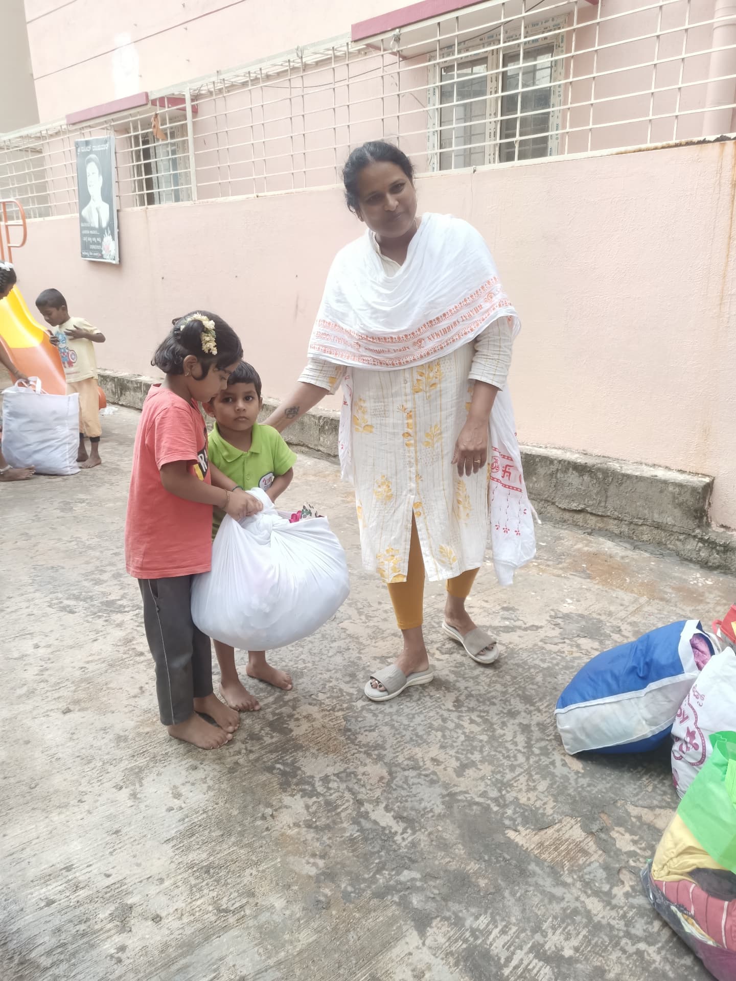 A girl carrying a bag of donated items handed over by a REIN volunteer