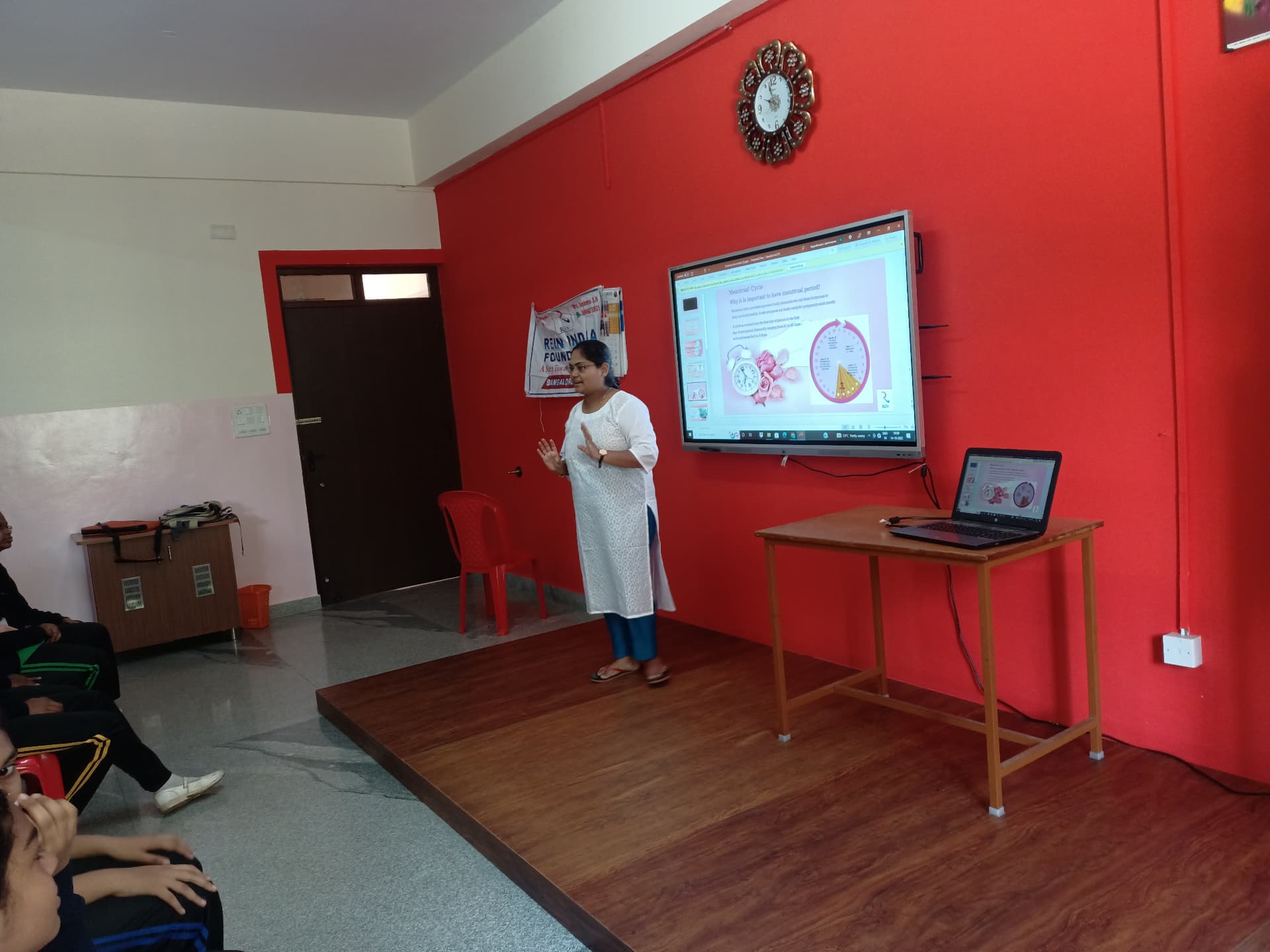 Educator explaining the menstrual cycle during a school awareness session