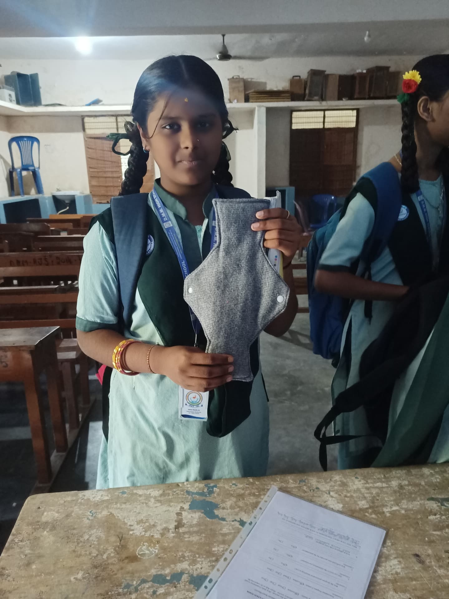 School student holding a reusable menstrual pad after a menstrual health session