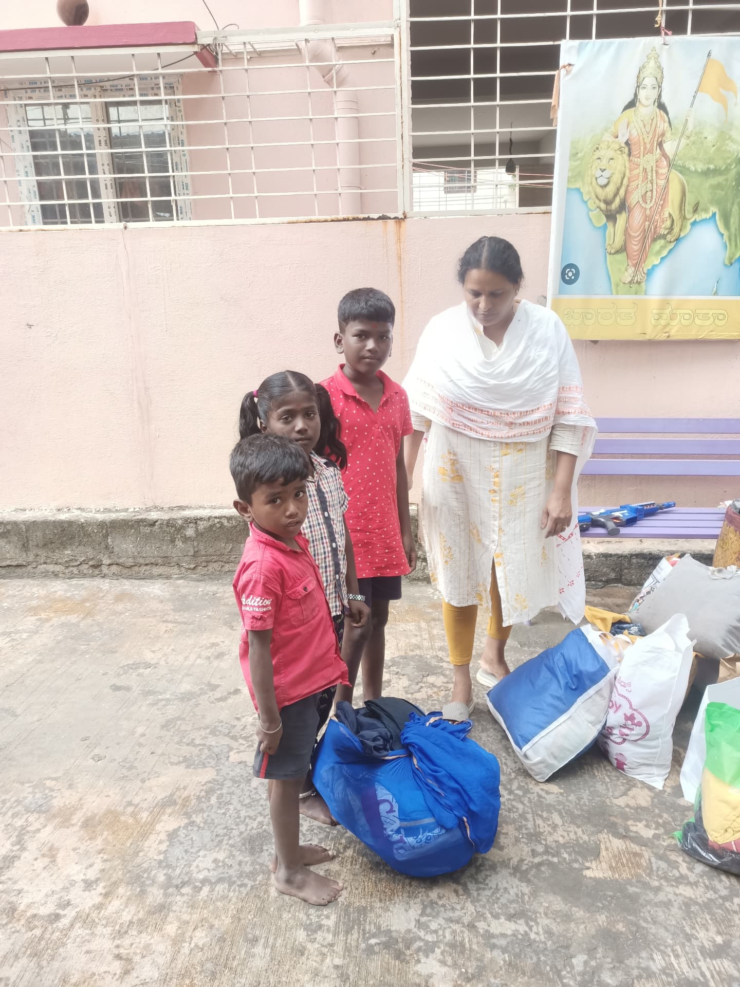 Children receiving bundles of donated clothes and essentials