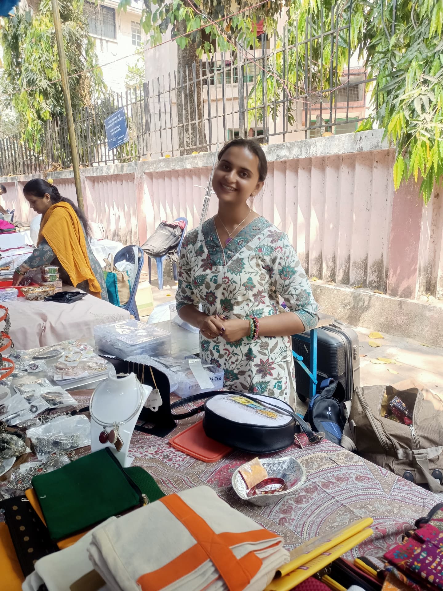 Woman showcasing handmade products at a community market stall